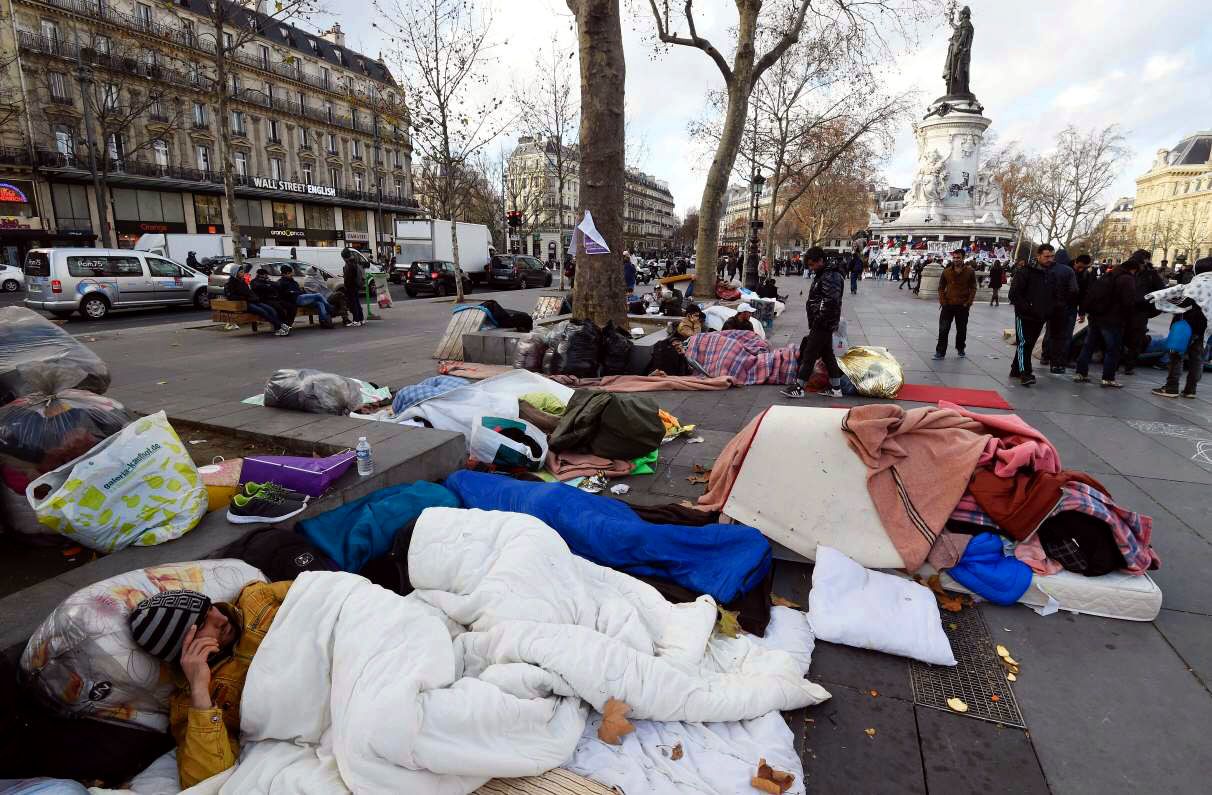 Un grupo de migrantes y refugiados provenientes de Afganistán duermen en la calle en París.